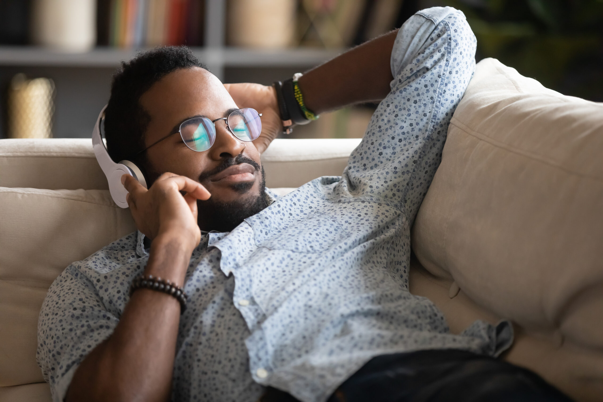 Satisfied Relaxed African American Man Enjoying Favorite Music O